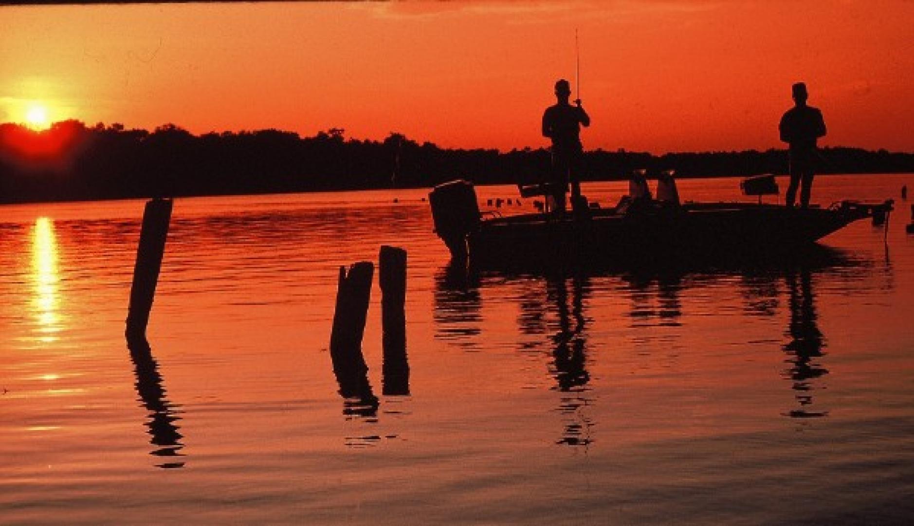 Fishermen in boat at sunset on water How to Be a Good Boat Fishing Partner