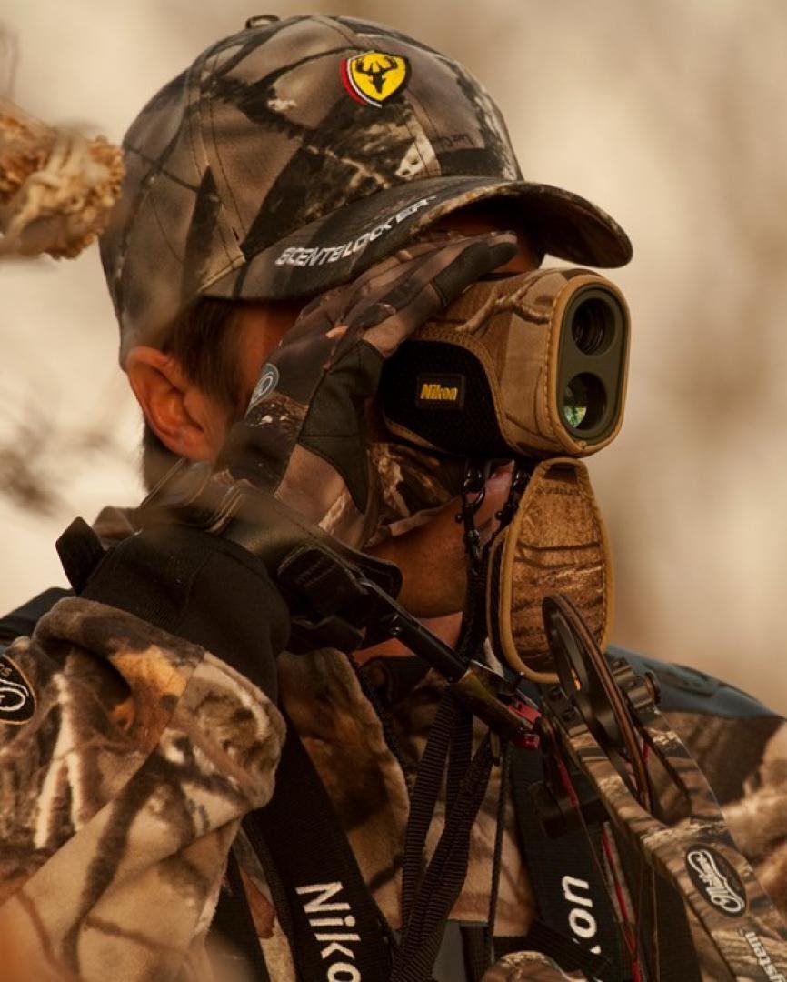 Hunter looking through rangefinder The Best Rangefinders for Hunting in 2022