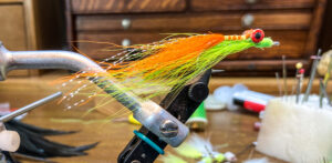 Clouser minnow fly in a rotary vice. hand tied fishing flies